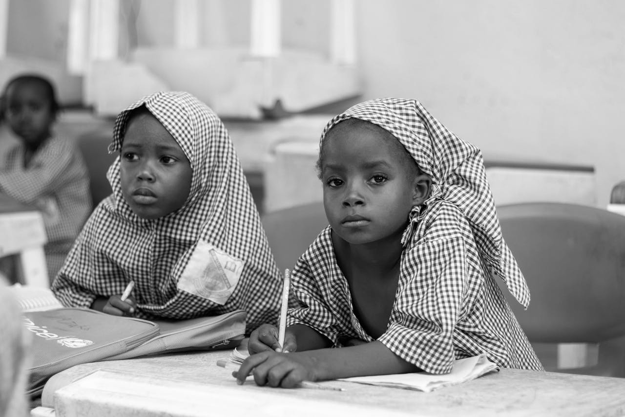 about-us-01 Black and white photo of young girls focusing on studies in a classroom.